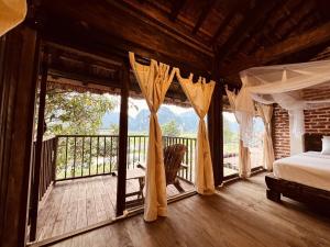 a bedroom with a bed and a balcony at Nabum Retreat in Làng Giang