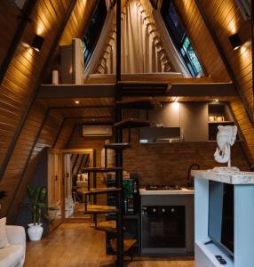 a loft kitchen with a spiral staircase in a house at Delta Casa Ubud - A-Frame Jungle Retreat with Volcano View and Hot-Tubs in Gianyar