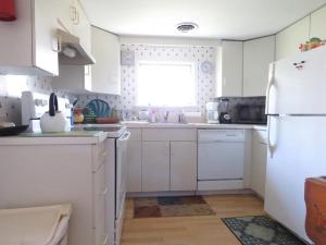 a kitchen with white cabinets and a white refrigerator at Parsons Folly Unit 3 in Cape May Point +4 photos