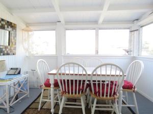 a dining room with a table and chairs and windows at Parsons Folly Unit 3 in Cape May Point