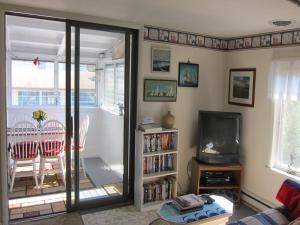 a living room with a tv and a table with a dining room at Parsons Folly Unit 3 in Cape May Point