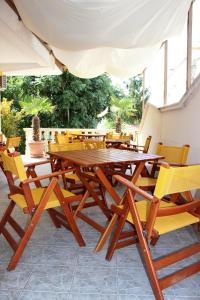 a wooden table and chairs sitting under an umbrella at Villa Amadeus in Nesebar