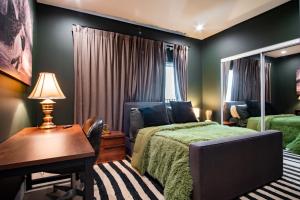 a bedroom with a bed and a table and a desk at Emerald Elephas at Case Collective in North Hollywood