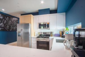 a kitchen with a refrigerator and a stove top oven at Emerald Elephas at Case Collective in North Hollywood