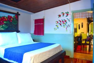a bedroom with a blue and white bed and a window at FILANDIA HOTEL in Filandia