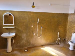 a bathroom with a sink and a toilet and a shower at Galaxy Lounge in Arugam Bay