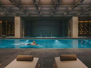 a person swimming in a swimming pool at Fairmont Hanoi in Hanoi
