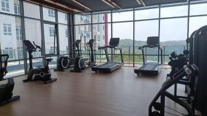 a gym with a bunch of exercise bikes in a room with windows at Adilili Mesahill Premier Homestay, Nilai near KLIA USIM AEON Mall Mesa Mall Aurelius Hospital in Nilai