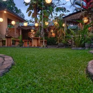 a yard with green grass in front of a house at The Winaposa in Munduk