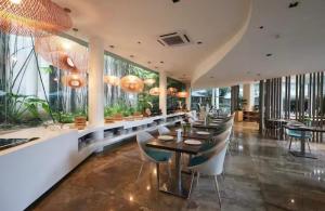 a dining room with tables and chairs and windows at Carolina Peach, Studio unit E-6H Tambuli Resort! in Maribago