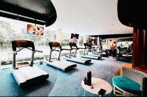 a gym with a row of exercise machines in a room at Carolina Peach, Studio unit E-6H Tambuli Resort! in Maribago