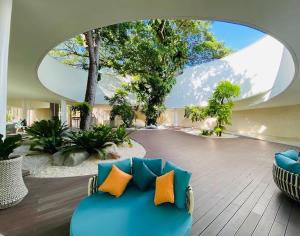 a living room with a blue couch with orange pillows at Carolina Peach, Studio unit E-6H Tambuli Resort! in Maribago