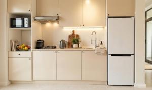 a kitchen with white cabinets and a refrigerator at Villa Fratello in Baku