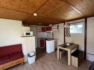 a living room with a red couch and a kitchen at Chalet avec terrasse - 7 pers. - API-1-52-2181 in Lattes
