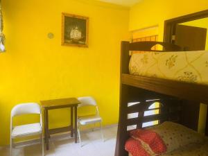 a bedroom with a bunk bed and a table and chairs at Small room with bunk bed, bathroom, AC and WiFi in Ing. Alberto Acuña Ongay International Airport +3 photos