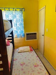 a bedroom with a bed and a window and a rug at Small room with bunk bed, bathroom, AC and WiFi in Ing. Alberto Acuña Ongay International Airport