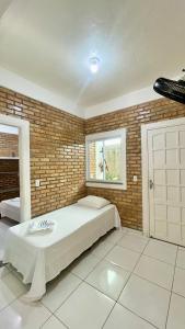 a bedroom with a bed and a brick wall at Chalés Santo Antônio em Flecheiras in Flecheiras