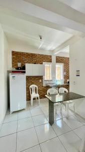 a kitchen with a table and chairs and a refrigerator at Chalés Santo Antônio em Flecheiras in Flecheiras