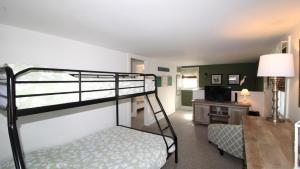 a bedroom with a bunk bed and a living room at Gray Cottage On Windsor in Cape May