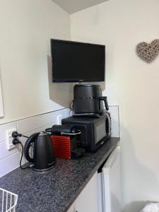 a kitchen counter with a television and a microwave at Queen Charlotte Bach in Linkwater