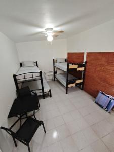 a room with two bunk beds and two chairs at Bungalow privado con alberca Oaxtepec 14 personas in Oaxtepec