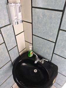 a bathroom with a black sink and a mirror at Bungalow privado con alberca Oaxtepec 14 personas in Oaxtepec
