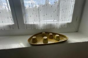 a tray with four cups sitting on a window sill at Maison a Confluence T2BZ-Tram in La Mulatière