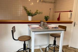 a table in a kitchen with two stools at Maison a Confluence T2BZ-Tram in La Mulatière