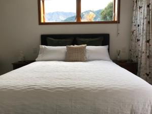 a bedroom with a large white bed with a window at Lakeview QT in Queenstown