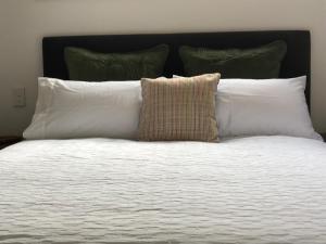 a bed with white pillows and a black headboard at Lakeview QT in Queenstown +1 photo