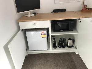 a desk with a microwave and a small refrigerator at Lakeview QT in Queenstown