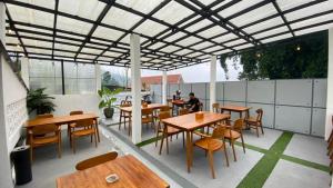 a patio with tables and chairs and a person sitting at a table at Kahyuna Hotel Bromo in Sukapura