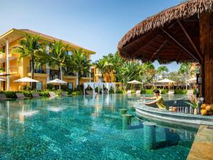 a person sitting in a pool at a resort at Sen Village Hoi An in Hoi An
