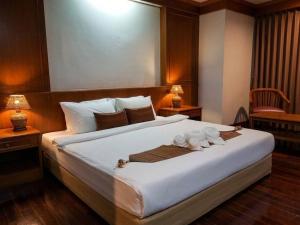 a bedroom with a large bed with two stuffed animals on it at Lanna Oriental Maejo in Chiang Mai