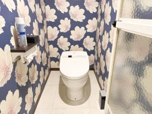 a bathroom with a toilet with flowers on the wall at ホテルアクアAdult Only in Hiroshima +2 photos