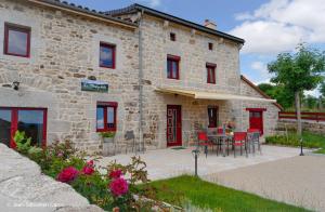 a stone house with a table and chairs in front of it at Gîte la margeride 4 personnes in Julianges