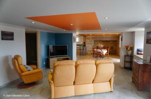 a living room with a couch and a dining room at Gîte la margeride 4 personnes in Julianges