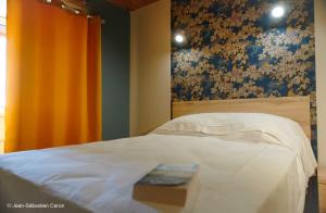 a bedroom with a bed with a book on it at Gîte la margeride 4 personnes in Julianges