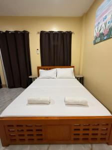 a large bed in a room with black curtains at Boboy's Guest House in Daro