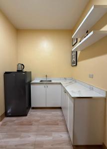 a kitchen with a sink and a refrigerator at Boboy's Guest House in Daro