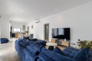 a living room with blue couches and a tv at Rocky 36 in Grand-Baie