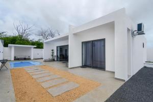 a white house with a pool in the yard at Rocky 36 in Grand-Baie
