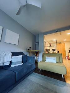 a living room with a blue couch and a chair at Real 92 in Arguedas