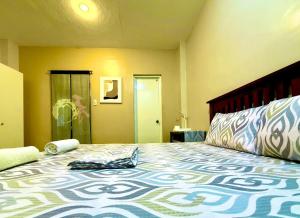 a bedroom with a large bed with a blanket on it at Boboy's Guest House in Daro +2 photos