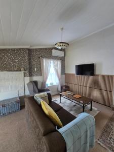 a living room with a couch and a table at Dalton's Deed in Roxburgh