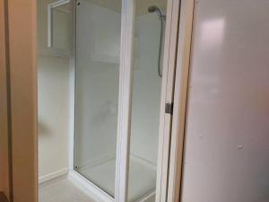 a white glass shower door in a room at At Eden Park Motel in Auckland +66 photos