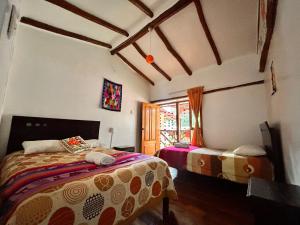 a bedroom with two beds and a window at Willka Lodge in Ollantaytambo