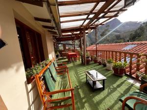 a balcony with chairs and tables and a table at Willka Lodge in Ollantaytambo