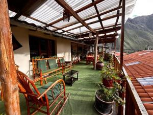 a patio with chairs and potted plants on a building at Willka Lodge in Ollantaytambo