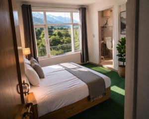 a bedroom with a bed and a large window at Apple Garden Aleo in Manāli
